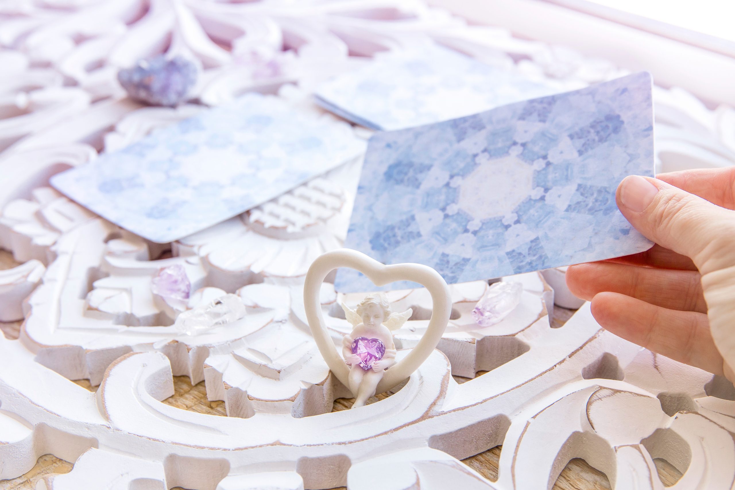 Deck with divination homemade Angel cards on bright white table,